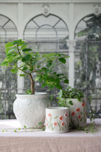 Krukor Poppy och Eliza i vitt keramik med blommönster och gröna växter.